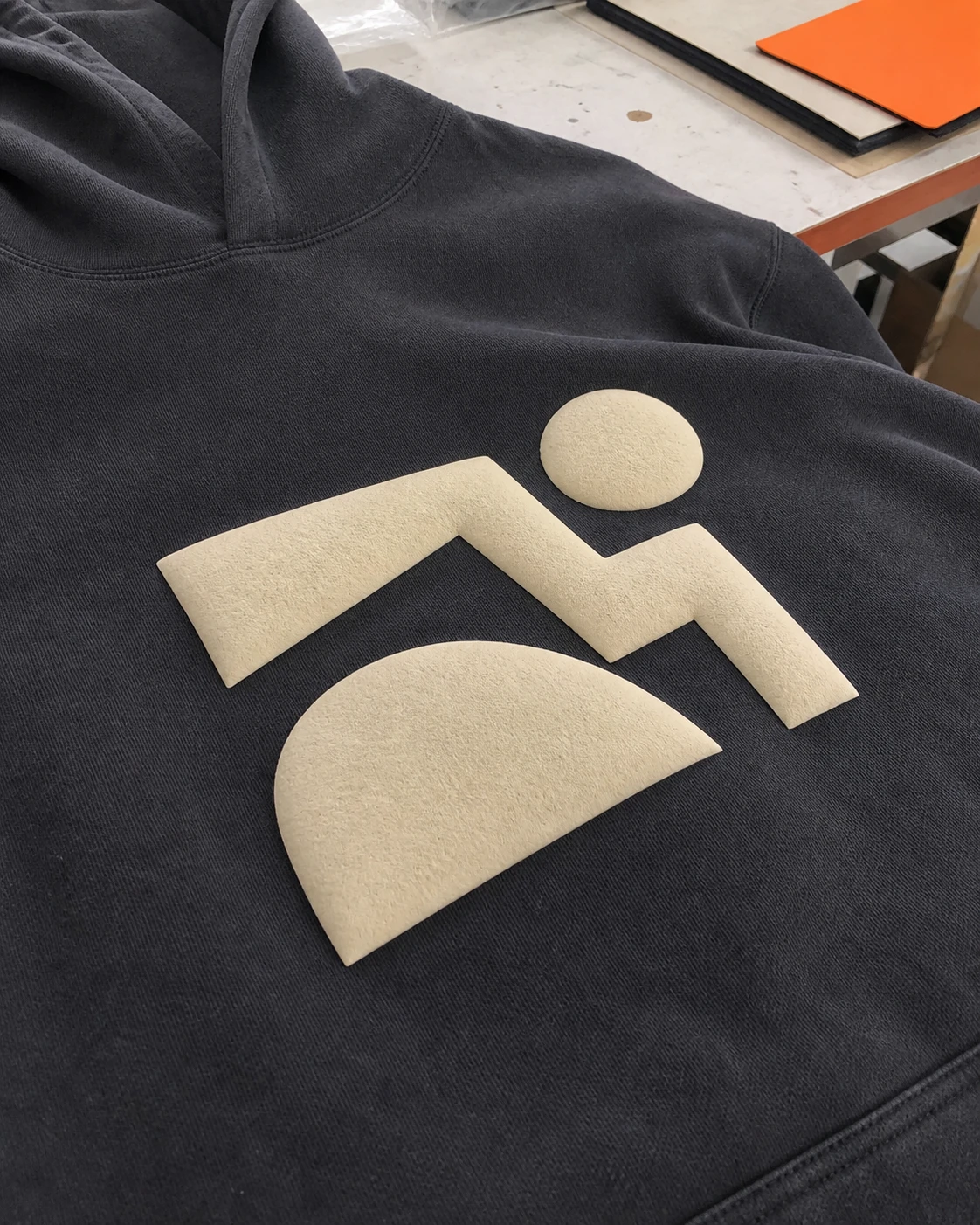 Raised puff lettering on a dark cotton hoodie