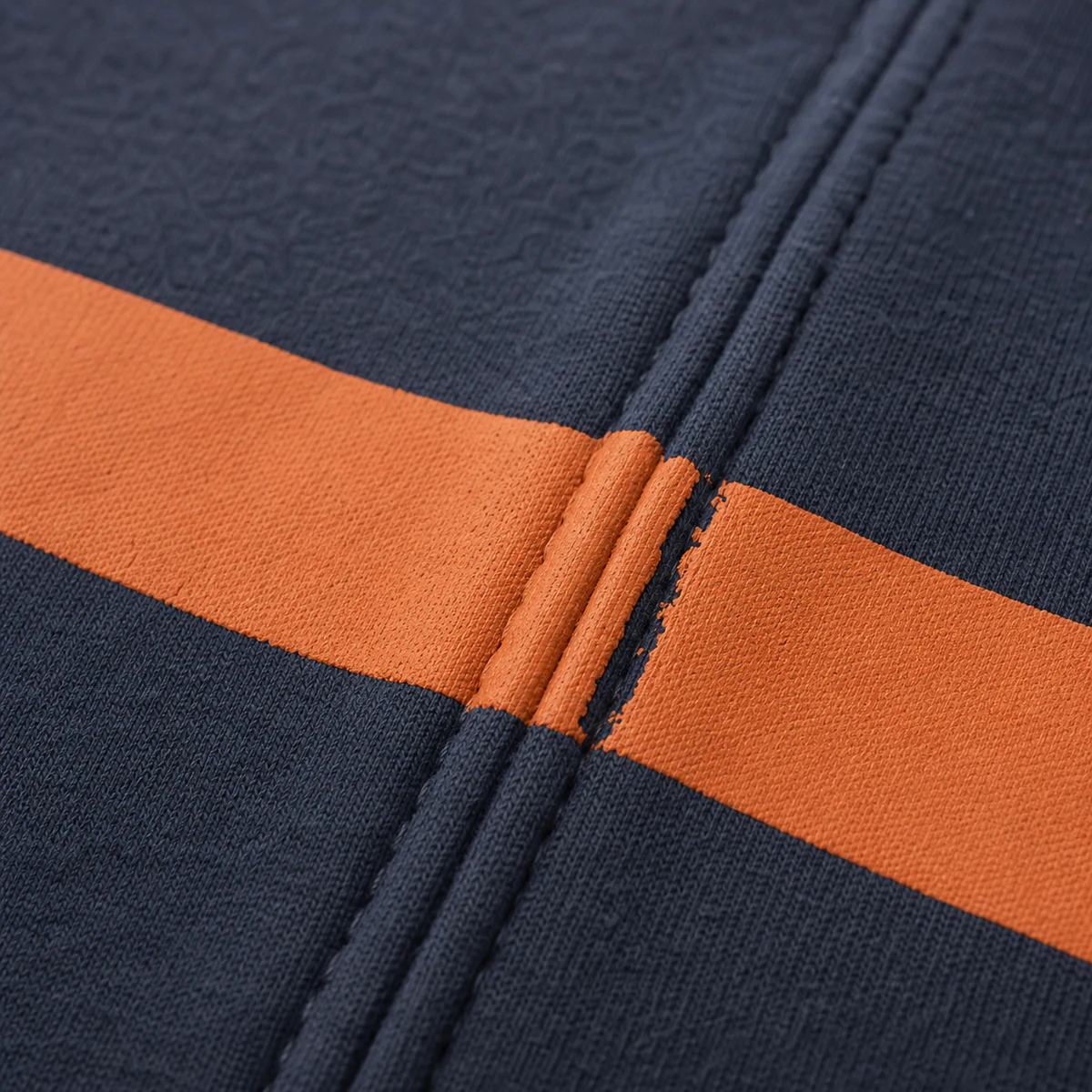 Uneven screen-print coverage and ink build-up across a garment seam